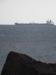 A cargo ship against a grey sky and sea